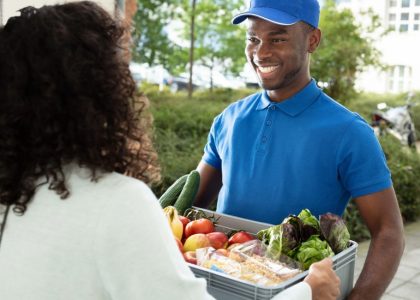Persona che consegna la spesa a domicilio, simbolo della crescita del mercato Food & Grocery online in Italia e dell’evoluzione degli acquisti alimentari digitali nel 2026.