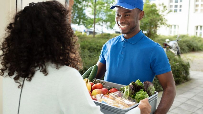 Persona che consegna la spesa a domicilio, simbolo della crescita del mercato Food & Grocery online in Italia e dell’evoluzione degli acquisti alimentari digitali nel 2026.